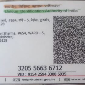 Aadhaar card showing resident details on the left and a large QR code on the right with UIDAI branding above.