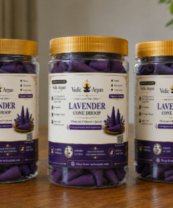 Three jars of lavender cone dhoop incense from Vedic Arpan on a wooden table, with purple cones visible inside and gold lids nearby.”,